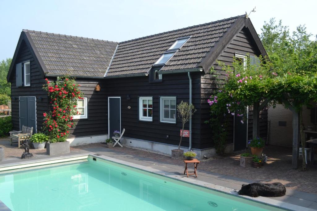 Sint-OedenrodeHet Steenuiltje的一座房子前面设有游泳池