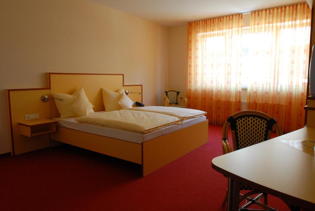埃默里希安姆潘酒店的一间卧室配有一张床、一张桌子和一个窗户。