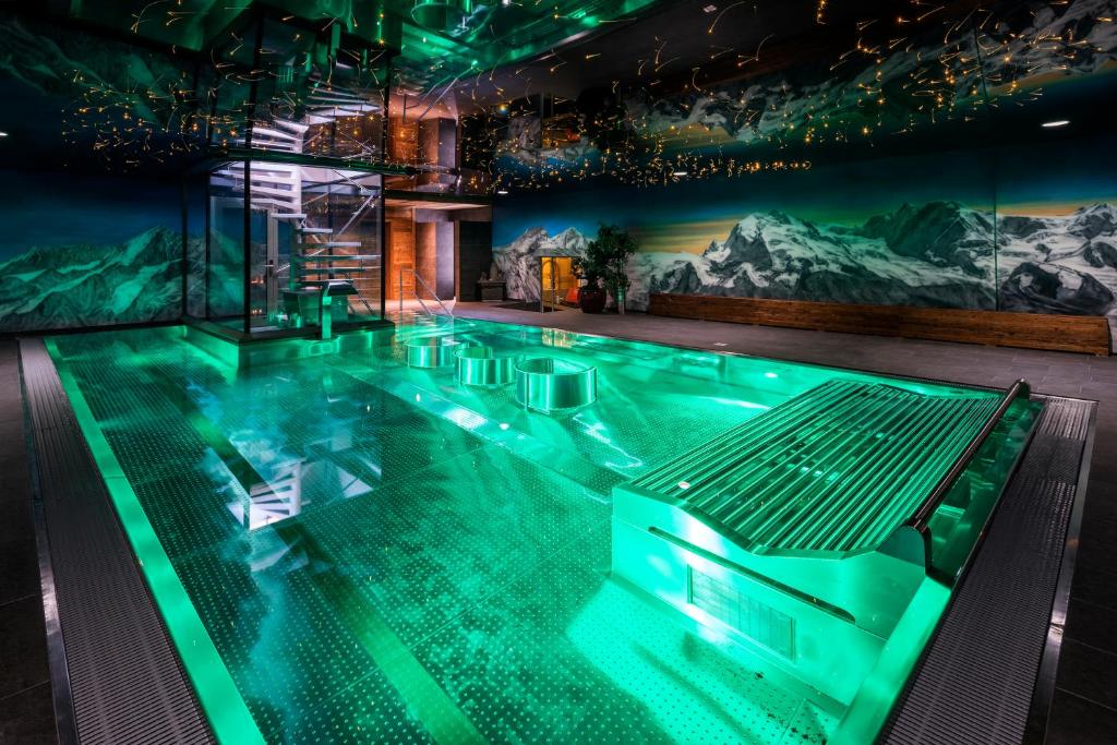 采尔马特西尔瓦娜山酒店的一座拥有山壁画的建筑里的一个大型游泳池