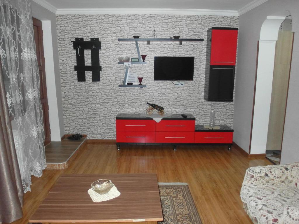 博尔若米拉兹卡公寓的客厅配有红色橱柜和电视