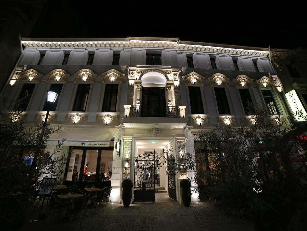 布加勒斯特The Mansion Boutique Hotel的白色的建筑,晚上有灯