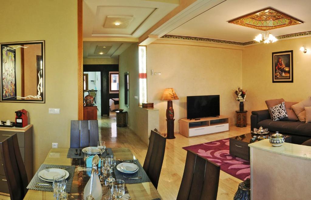 非斯莱斯奥利弗斯套房＆Spa公寓式酒店的客厅配有桌子和沙发
