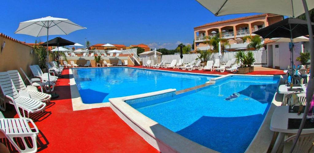 拉隆德莱丝莫里斯Argentiere-Club的一个带白色椅子和遮阳伞的大型游泳池