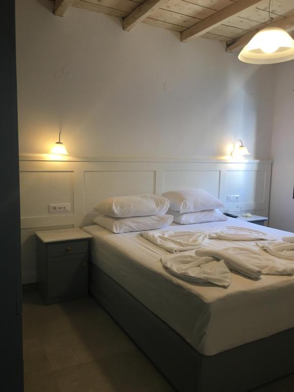 鲁特罗Hotel Porto Loutro on the Hill的一间卧室配有带白色床单和枕头的床。