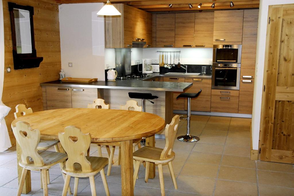 Saint-EustacheGîtes Les Pralets的厨房配有木桌和椅子