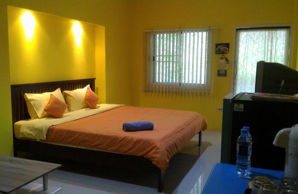 安帕瓦班本加希旅舍 的一间卧室设有一张黄色墙壁的大床