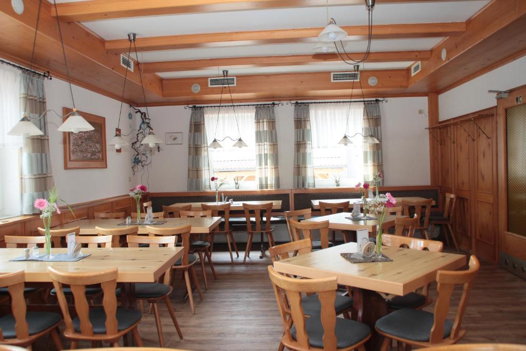 弗里德贝格格斯凯赛酒店的餐厅设有木桌、椅子和窗户。