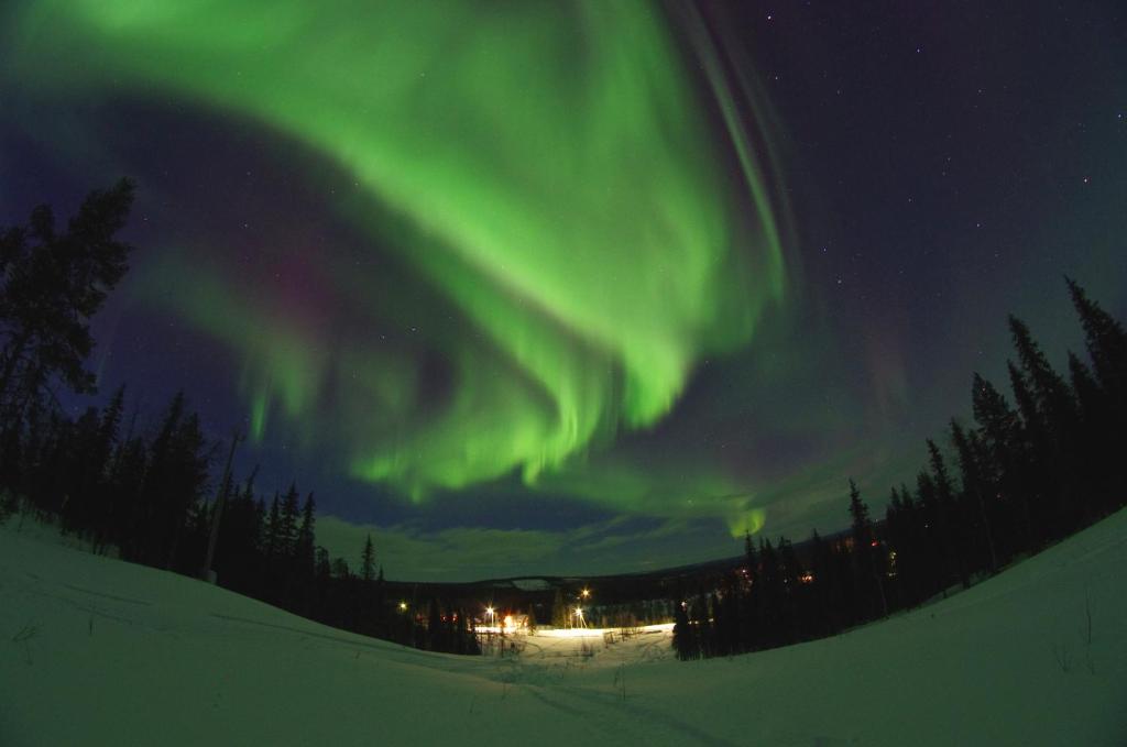 MasugnsbynLapland Snow Cabin的天空中极光舞的图像