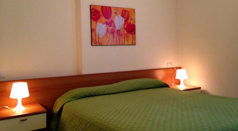 科利科Green Village Accommodations的一间卧室配有一张带两盏灯的绿床。