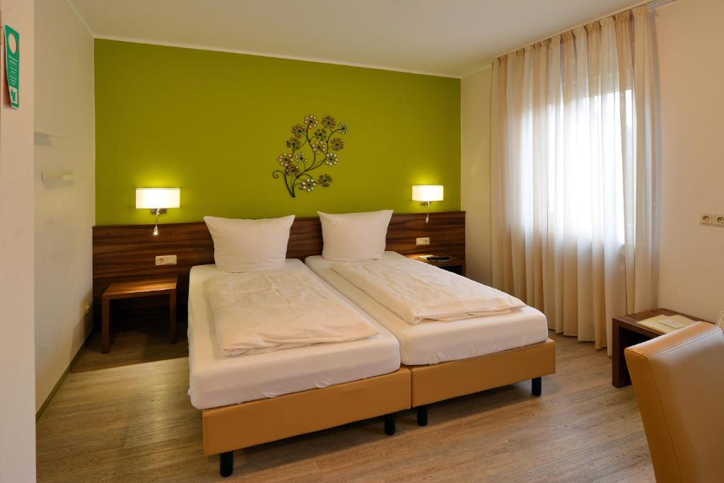 特里尔Hotel L' Angolo的一间卧室配有一张带绿色墙壁的床