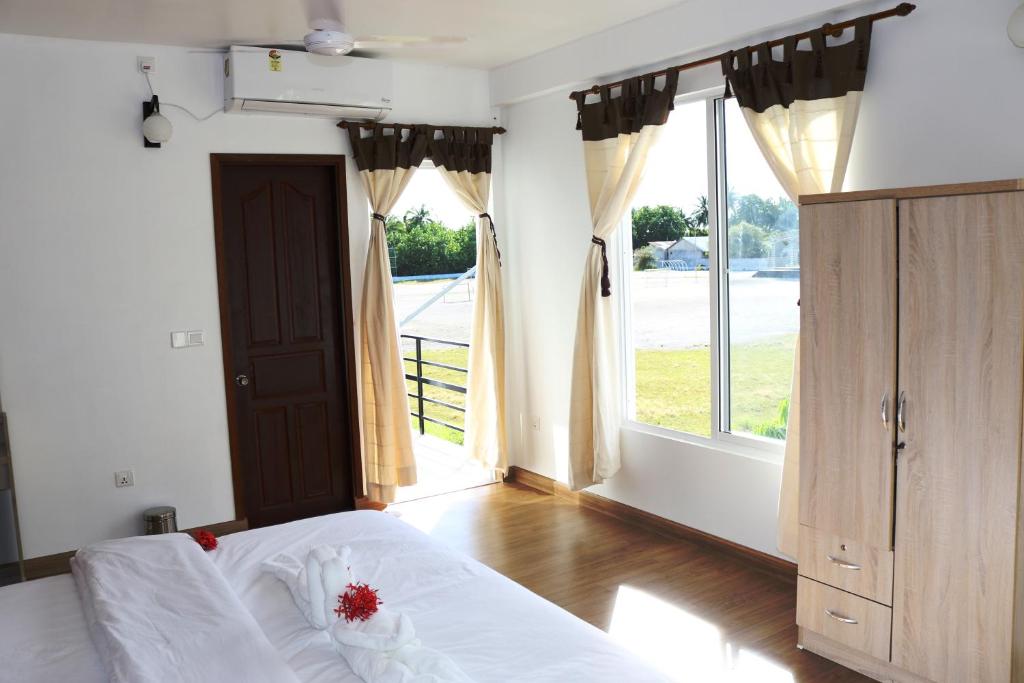 拉斯杜拉斯杜环礁蓝水旅馆的一间卧室设有一张床和一个大窗户