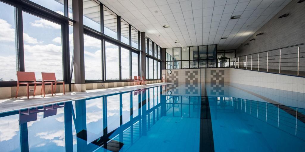 塞内奇海豚酒店的一座带窗户的建筑中的游泳池