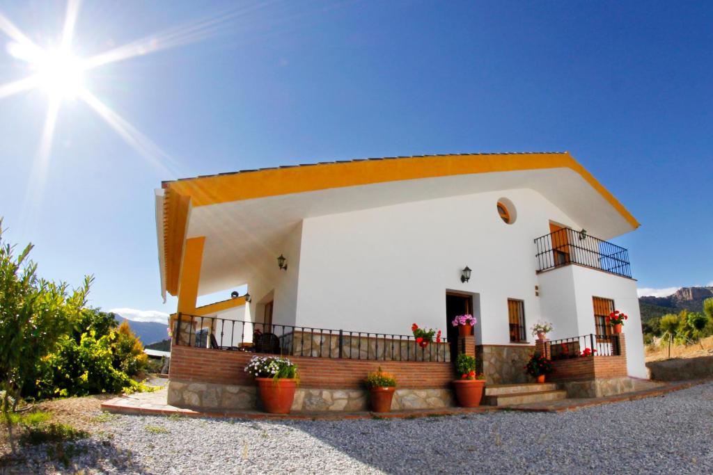 卡斯特里尔Alojamiento Rural Sierra de Castril的前面有盆栽植物的小白色房子