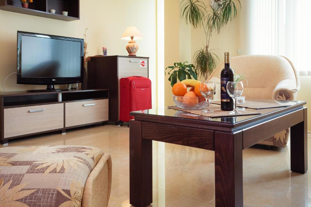 普罗夫迪夫布莱特豪斯宾馆的客厅配有桌子,提供一瓶葡萄酒和水果