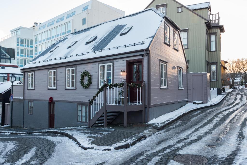 雷克雅未克雷克雅未克宝藏住宿加早餐酒店的雪中街道上的房屋