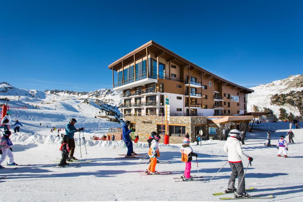 阿克2000Hôtel Taj-I Mah by Les Etincelles的一群滑雪者在滑雪小屋前滑雪