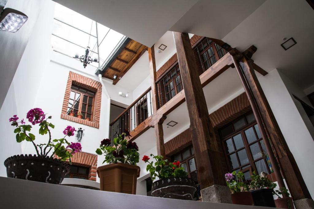基多厄瓜宝藏历史中心酒店的楼内带有盆栽的走廊