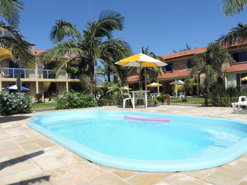 托雷斯Pousada Don Fernandes的一个带遮阳伞和房子的大型游泳池