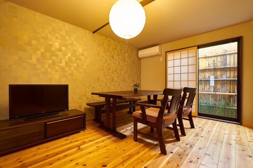 京都Kyoyado Hakuto的一间带桌子和电视的用餐室