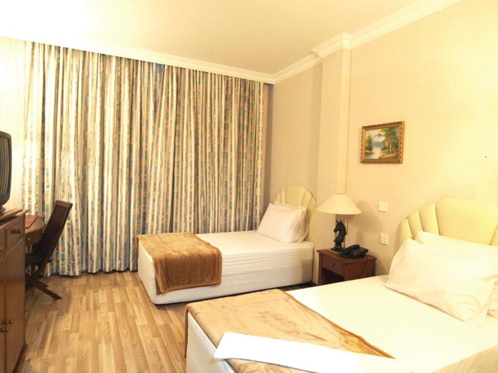 甘榜杰鲁登约鲁顿酒店的酒店客房设有两张床和电视。