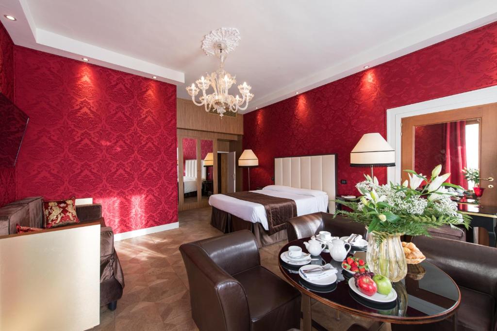 威尼斯Locanda Leon Bianco on the Grand Canal的一间客厅,拥有红色的墙壁和一间卧室