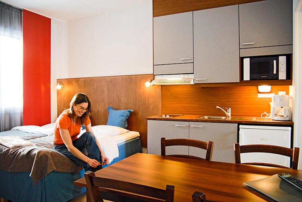 Oravi奥拉维公寓酒店的坐在酒店房间床上的女人