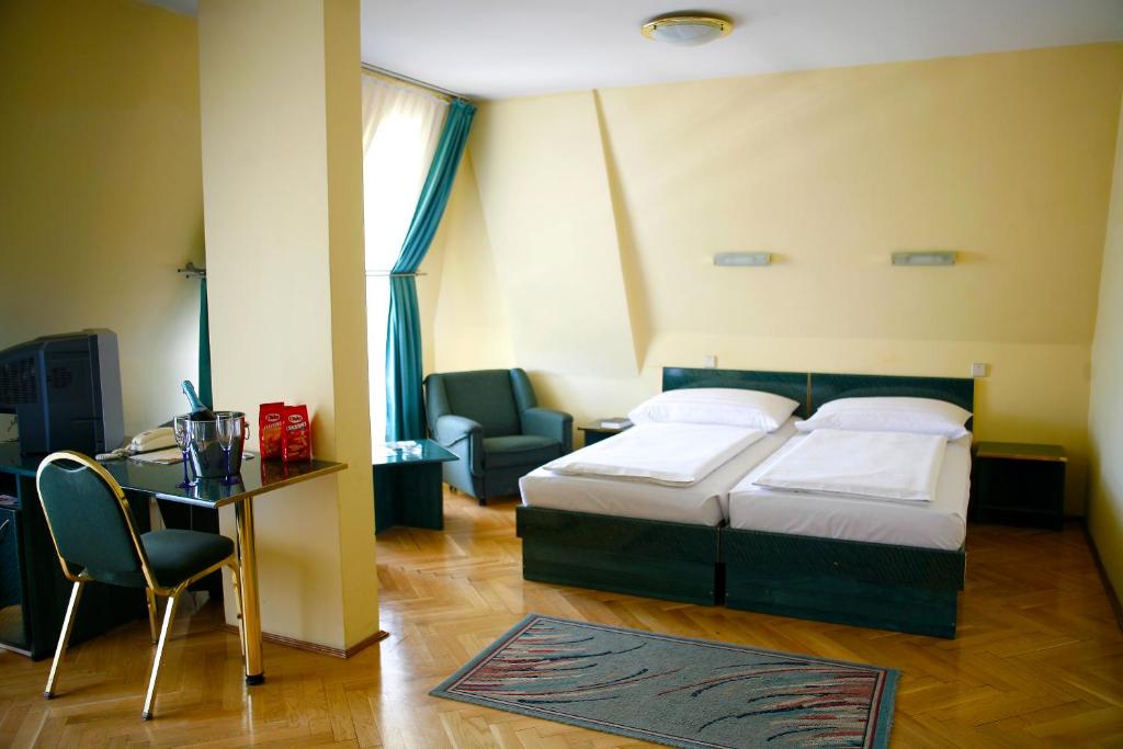 布达佩斯Hotel Bara Budapest的一间卧室配有一张床、一张桌子和一把椅子
