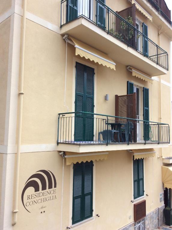 阿拉西奥Residence Conchiglia Aparthotel的带阳台的建筑,上面有标志