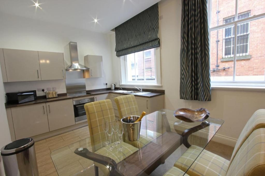 利物浦城堡系列 - 25号城堡街公寓的厨房配有玻璃桌和黄色椅子