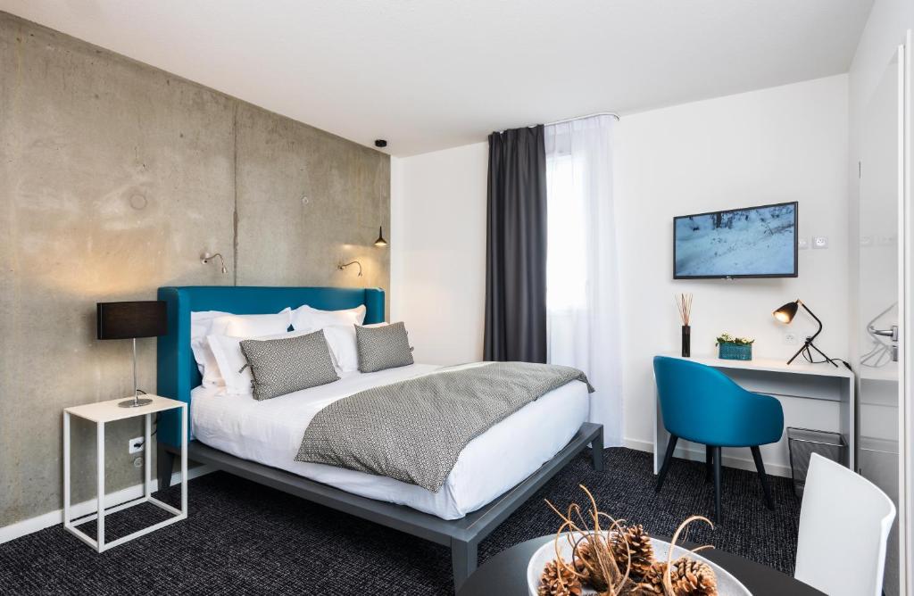 塔朗斯Ténéo Apparthotel Talence - Espeleta的配有一张床和一张书桌的酒店客房