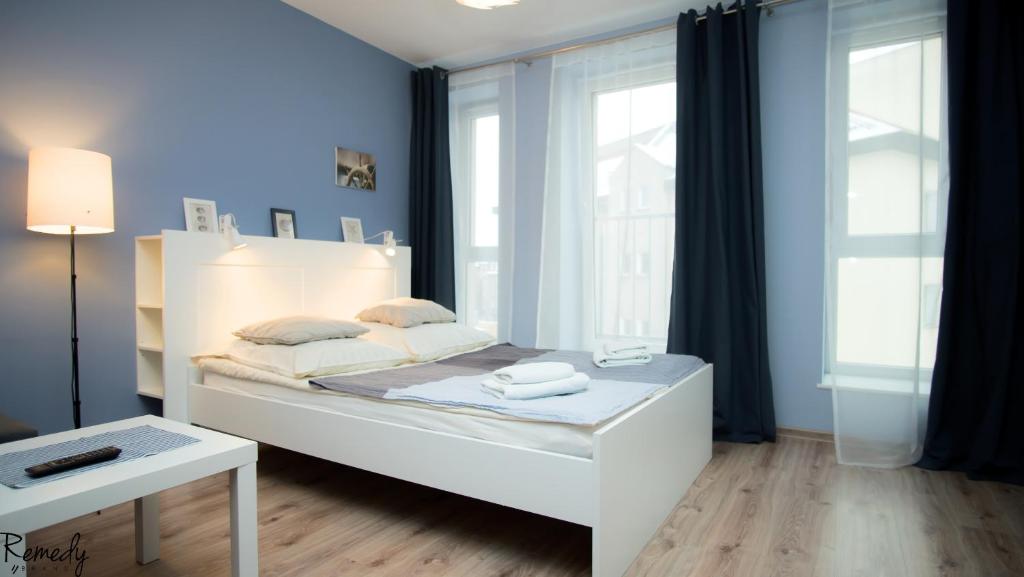 什切青Apartamenty Sedinum - Bryza的窗户客房内的一张白色床