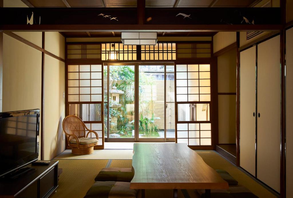 京都Kanki no Yado的客房设有桌子和大窗户。