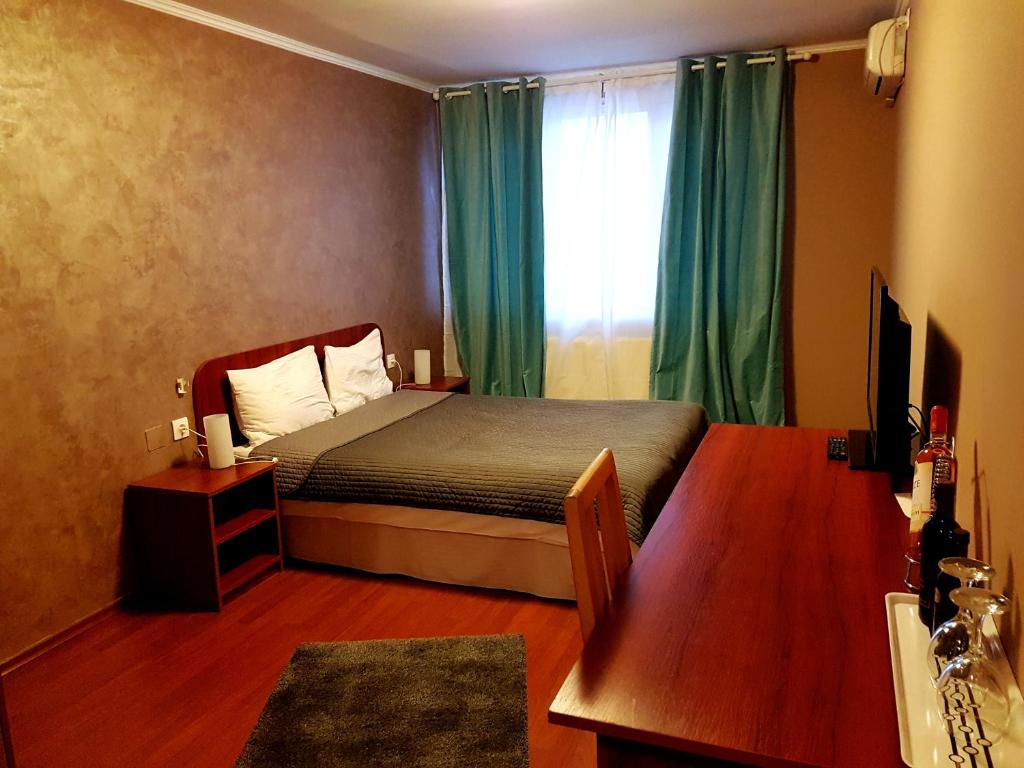 布加勒斯特麦克酒店的一间卧室设有床铺和一个带绿色窗帘的窗户。
