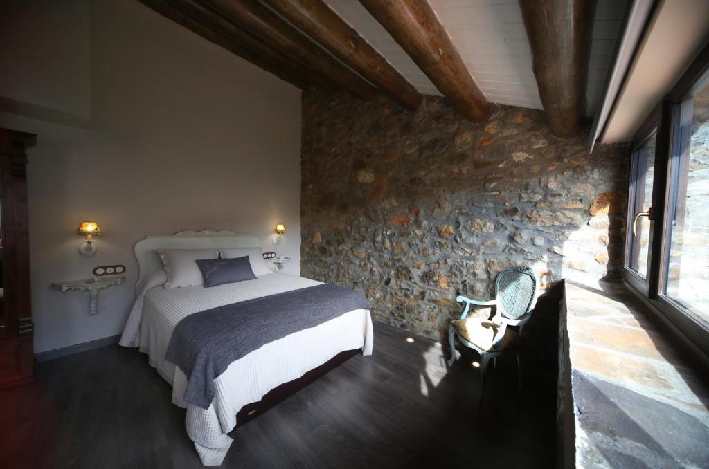 拉斯普纳El Capricho de Nieves的一间卧室设有一张床和石墙