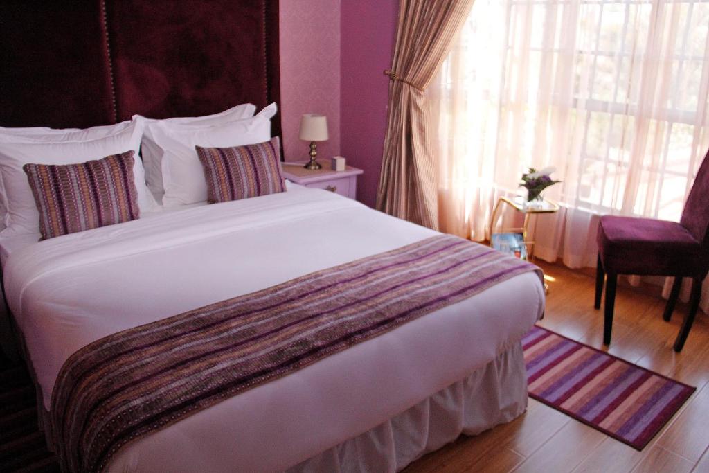 内罗毕萨尔米亚广场旅馆的卧室设有一张白色大床和一扇窗户。