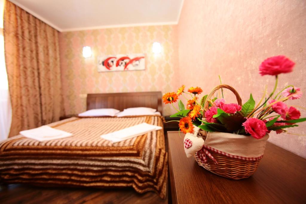 巴统奥比海塔楼公寓l酒店的一间酒店客房,配有一张床和一篮鲜花