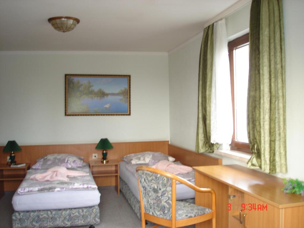 哈尔登斯莱本史瓦奈特膳食公寓酒店的一间卧室设有两张床、一张桌子和一个窗口。