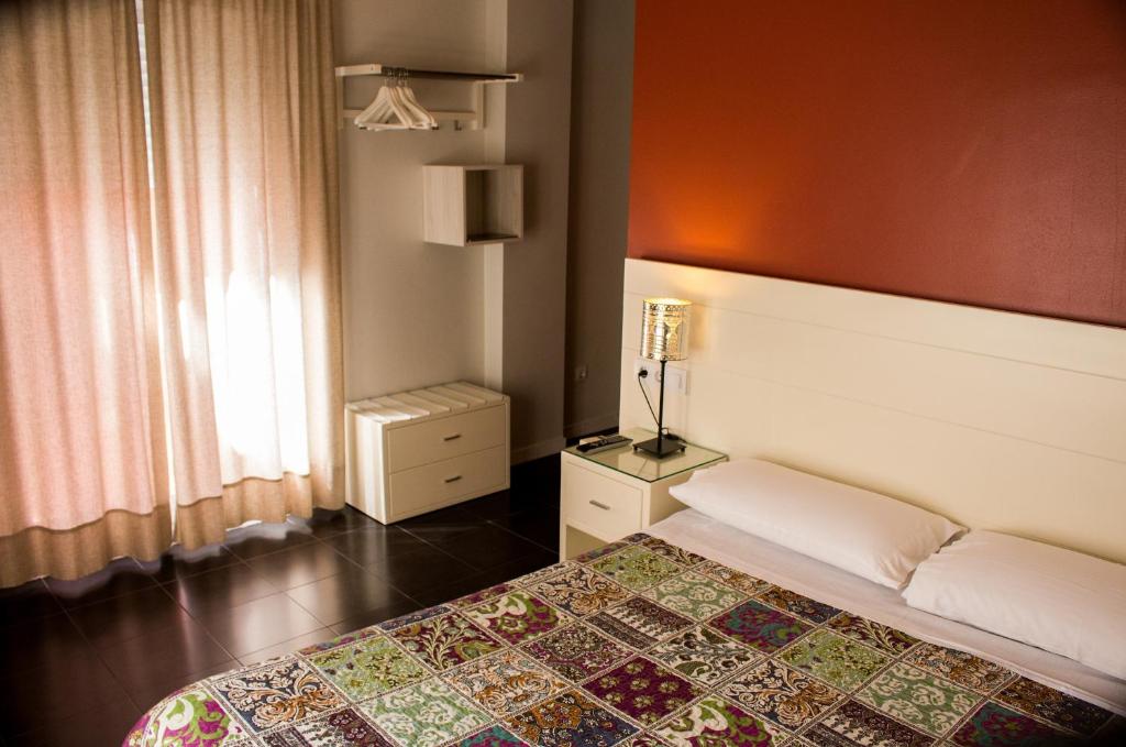 塞维利亚圣维森特2号旅馆的一间卧室设有一张床和一个窗口