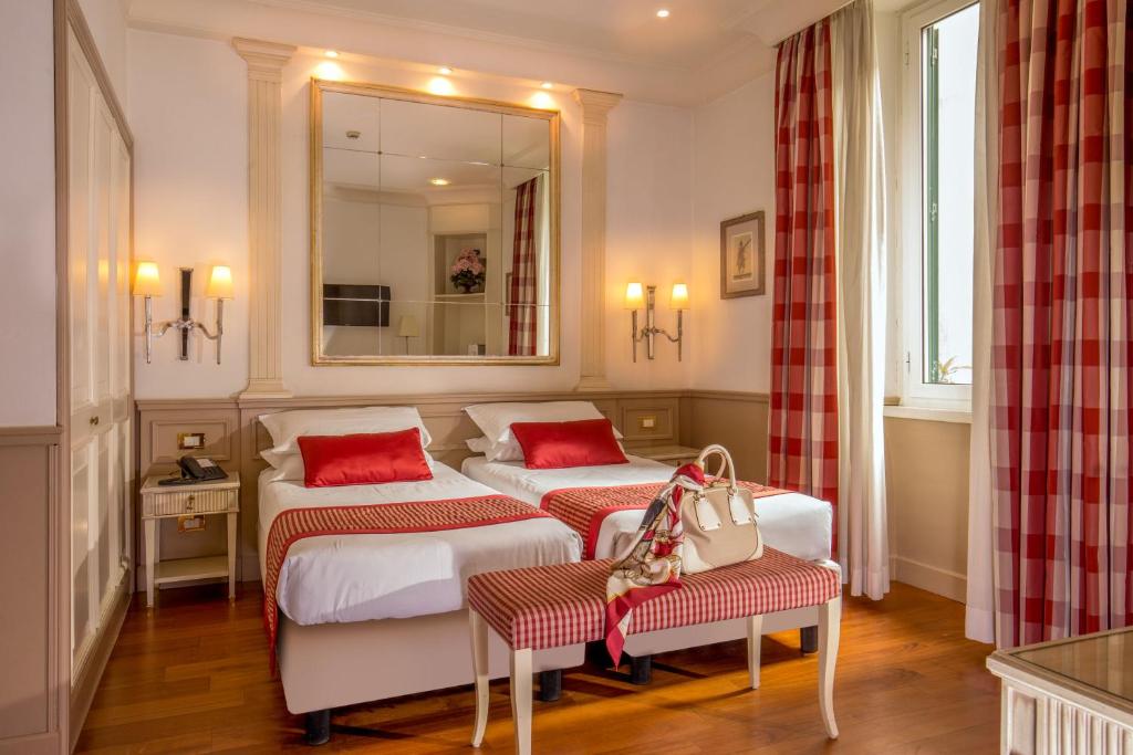 罗马葛罗丽别墅酒店的酒店客房,设有两张床和镜子