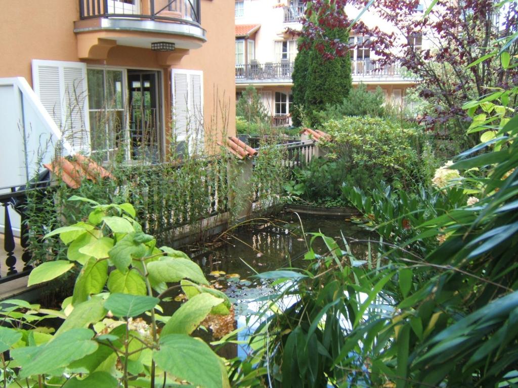 奥斯赛拜-屈隆斯博恩Ferienwohnung LAGUNA-Residenz am Meer/ Whg. 29的一座花园,在一座建筑前设有一个池塘