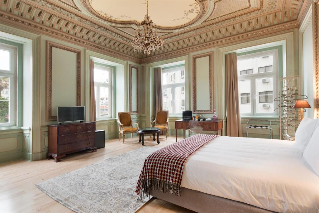 里斯本希尔都特索大巴萨旅馆的一间卧室配有一张大床和一个吊灯。