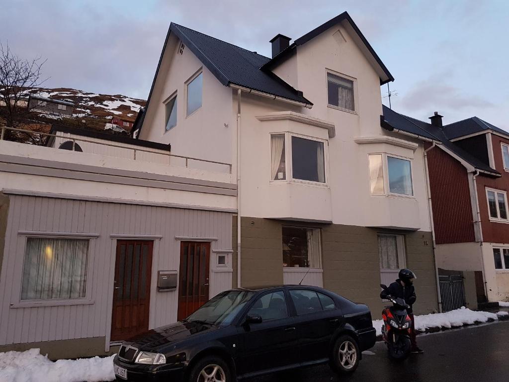 VestnanhavnBudget Guesthouse Borgustova的停在房子前面的一辆黑色汽车