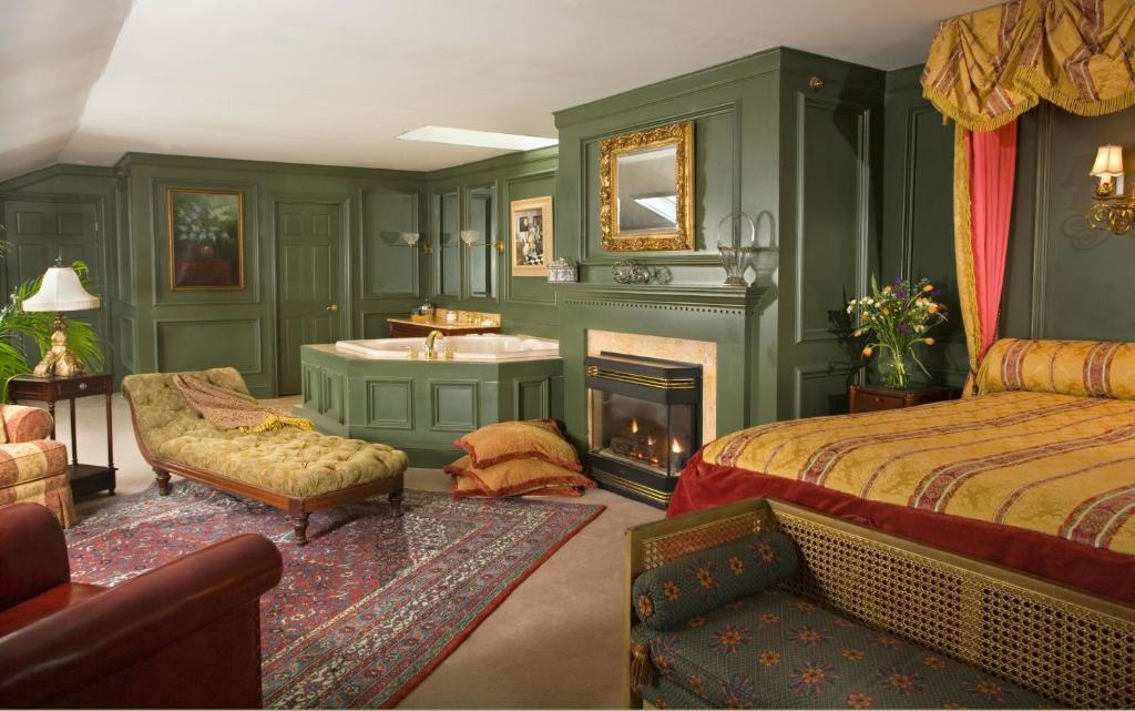 纽波特Hydrangea House Inn的一间卧室配有一张床、一个水槽和一个壁炉