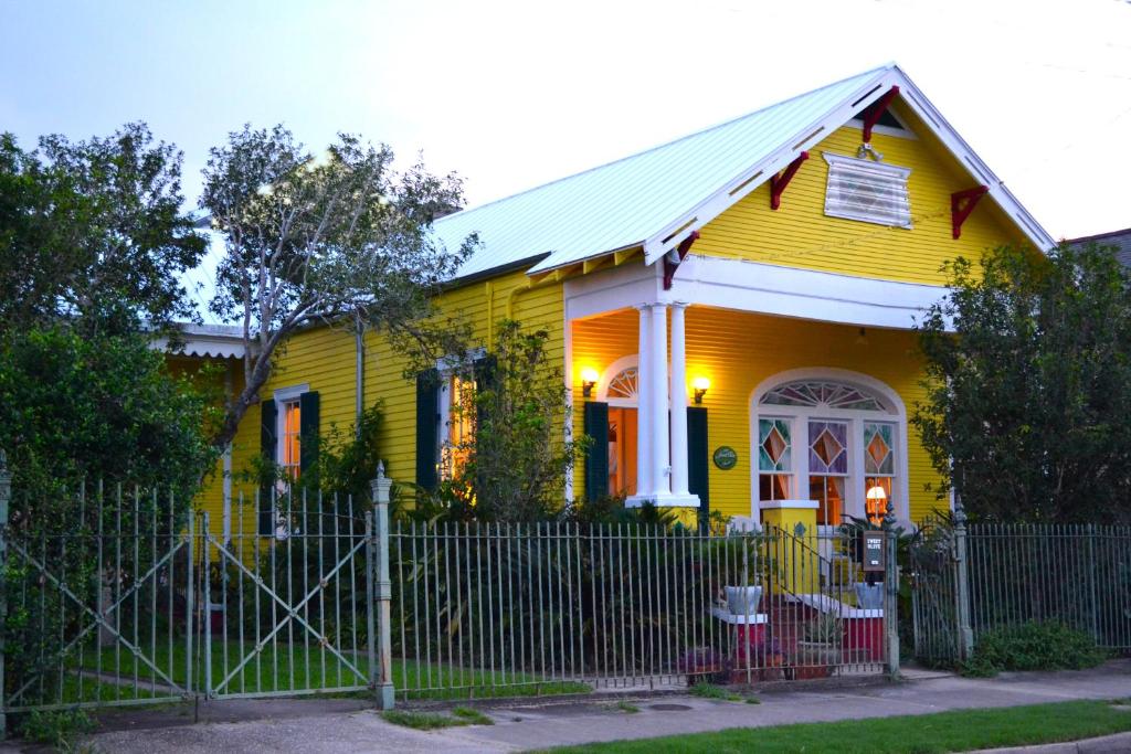 新奥尔良友谊甜橄榄住宿加早餐酒店的前面有栅栏的黄色房子