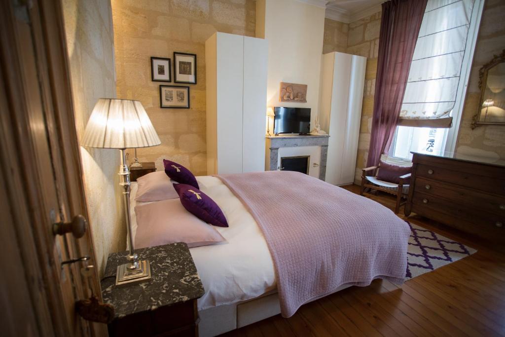 波尔多MAISON D'HÔTES "Bordeaux Wine Lodge"的一间卧室配有一张床和一张带台灯的桌子