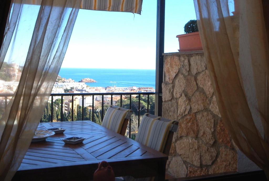 滨海托萨LETS HOLIDAYS SEA VIEWS APARTMENT & POOL in SA GABARRA的阳台的桌子享有海景