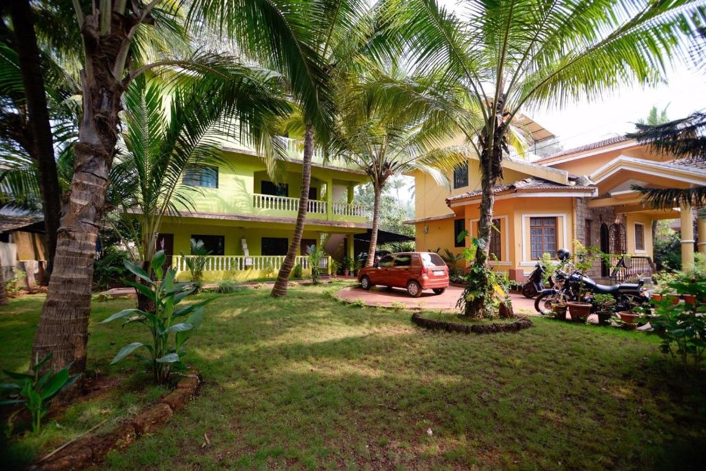 科尔瓦Sunshine Park Homes的一座棕榈树的房子和一座停车场