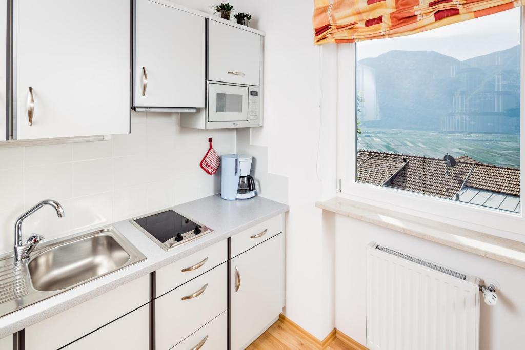 科尔塔恰Haus Sauvignon的白色的厨房设有水槽和窗户