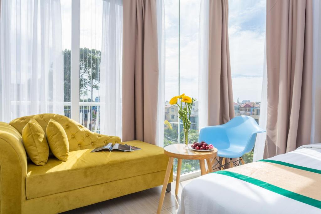 胡志明市卡米拉酒店的酒店客房设有黄色的沙发和窗户。