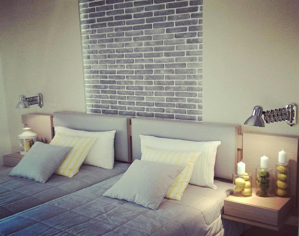 萨索斯银河城酒店的一张带三个枕头的沙发和砖墙